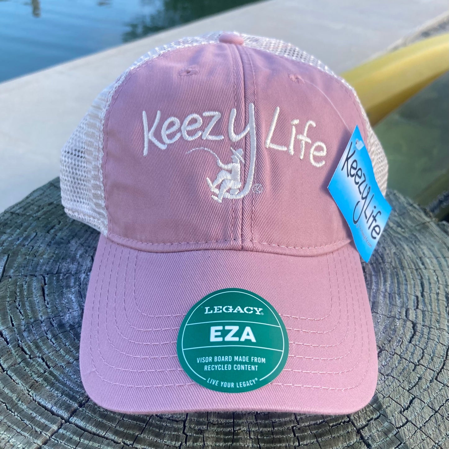 Dusty Rose trucker cap says Keezy Life. The letter Y has a boy fishing on the bottom of the Y.