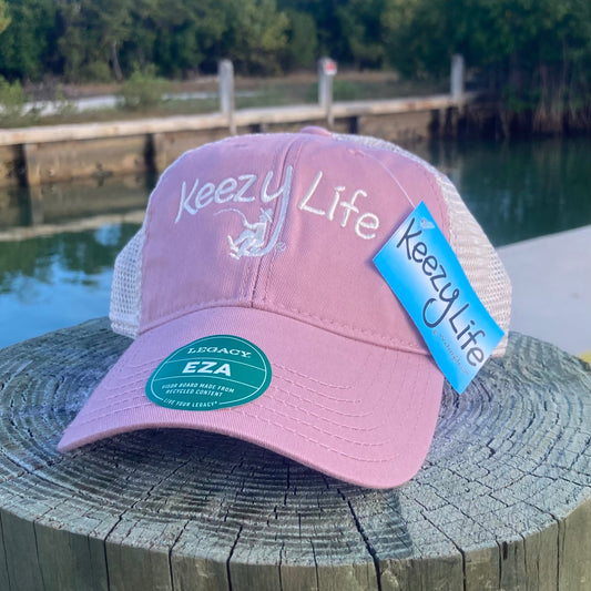 Dusty Rose trucker cap says Keezy Life. The letter Y has a boy fishing on the bottom of the Y.
